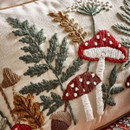 A close up view of a rectangle embroidered Catherine Lansfield woodland cushion