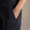 Close-up of zipped side pocket on black outdoor trousers with embroidered logo.