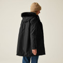 The back of a woman wearing a hooded black jacket with a faux fur trim.