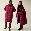 A man and woman wearing a dark red Regatta changing robe with a cosy fleece lining.