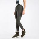 Woman wearing dark green leggings with a small "WEIRD FISH" logo near the waistband. She is also wearing a printed white T-shirt, green walking boots, and striped socks.