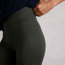 Close-up of dark green leggings with the "WEIRD FISH" logo embroidered near the waistband.