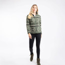 Woman wearing a deep lichen green fleece jacket with an off-white geometric pattern, zipped up to the collar. She is also dressed in black leggings and hiking boots.