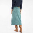The back of a person wearing a deep teal coloured denim midi skirt with brown boots.