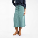 The front of a person wearing a deep teal coloured denim midi skirt with brown boots.