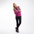 A woman laughing while wearing a purple wine patterned jumper paired with black jeans and dark brown ankle boots.
