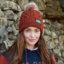 A view of a person wearing a russet coloured Ridgeline bobble hat