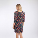 The back of a woman wearing a dark blue dress with a colourful all-over floral print.