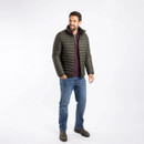 A full length view of a man wearing an anthracite grey padded jacket with jeans and boots.