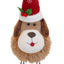 Close-up of a plush festive dog decoration with a fluffy brown coat, large white snout, red tongue, and a red Santa hat with white trim, holly leaves, and berries.