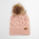A pink knit beanie with a large brown faux fur pom-pom on top. It features a textured, cable-knit pattern and a leather tag on the folded brim.