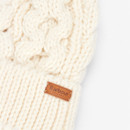 Close-up of a cream knitted beanie hat with thick cables, featuring a leather tag. The texture is cosy and warm, presenting an inviting winter feel.