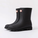 Black insulated Hunter short wellington boots angled together on a white background, featuring a matte rubber finish and chunky treaded soles.