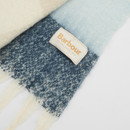 Close-up of a Barbour scarf with a gradient of white to blue tones. The Barbour label is visible, adding a touch of elegance and warmth.