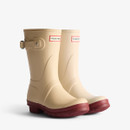 A pair of short Hunter wellingtons with a natural coloured upper and a contrasting red sole.