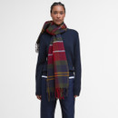 A person wearing a navy sweater and jeans is shown against a white background. They have a colourful plaid scarf draped around their neck, adding a cosy, stylish touch.