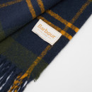 Dark blue and green tartan scarf with fringed edges. A tan label with "Barbour Established 1894" in orange text is sewn onto the fabric. Cosy and classic design.