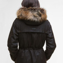 Rear view of a person wearing a dark jacket with a brown faux fur-trimmed hood. The jacket is cinched at the waist, suggesting warmth.