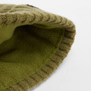 Close-up image of a knitted green beanie, showing its textured, ribbed edge and soft fleece lining. The tone is cosy and warm.