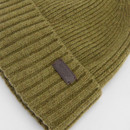 Olive green ribbed knit beanie with a brown leather patch, conveying a cosy and warm tone. The patch has embossed text, adding a touch of detail.