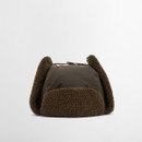 A brown trapper hat with fuzzy ear flaps and a soft, textured brim on a plain white background. The style exudes warmth and comfort.