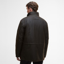Alt text: "Man in a dark brown jacket standing with his back to the camera. The jacket has a high collar and a small label on the upper back. Minimalist setting."