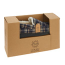 A men’s tartan moccasin slipper in navy, beige, and brown, partially packaged in a brown Jo & Joe branded cardboard box with a visible fleece lining and tag.