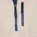 Close-up of a Lazy Jacks women's sherpa fleece sweatshirt in cream, highlighting two vertical chest zippers with blue trim and black zipper pulls. The textured fleece fabric and seam stitching are clearly visible.