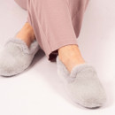 Person seated cross-legged wearing light pink loungewear and soft, fluffy grey slippers with a high-cut design and faux fur texture, on a pale pink background. Person seated cross-legged wearing light pink loungewear and soft, fluffy grey slippers with a high-cut design and faux fur texture, on a pale pink background.