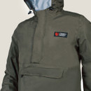 Close-up of the Stoney Creek Men’s Stow It Jacket in Gumleaf, showing the hood, half-zip front, and large chest pocket with the Stoney Creek logo patch.