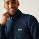 Smiling person wearing a navy fleece jacket with "Regatta Great Outdoors" logo. The tone is warm and casual, suggesting comfort and satisfaction.