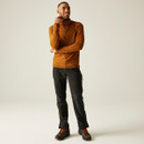 Man wearing the Yonder II men’s fleece in Pumpkin Spice, standing confidently in full-length view. Styled with black outdoor trousers and hiking boots, ideal for hiking and layering in cold weather.