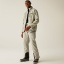 Full-body shot of a smiling man in the Abbey Stone fleece jacket styled with pale outdoor trousers and boots, wearing the jacket open over a base layer.