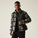 Front-facing image of a male model dressed in a black and grey plaid zip-up fleece jacket with contrast chest pocket and crossbody bag, smiling softly. Front-facing image of a male model dressed in a black and grey plaid zip-up fleece jacket with contrast chest pocket and crossbody bag, smiling softly.