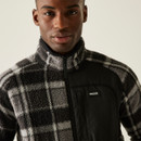 Close-up view of the chest and collar area of a grey and black check fleece jacket, highlighting the texture and Regatta Outdoors logo on the nylon pocket. Close-up view of the chest and collar area of a grey and black check fleece jacket, highlighting the texture and Regatta Outdoors logo on the nylon pocket.