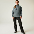 Full-body shot of a woman in the Element Grey fleece styled with black outdoor trousers and winter boots, standing with hands by her side.