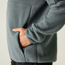 Close-up of the right hand inserted into the side pocket of the Element Grey fleece, showing texture, zip trim, and curved seam detailing.