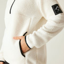 Detail of model’s hand inside one of the zipped lower kangaroo pockets, showing contrast edging on sleeve and pocket.