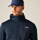 Close-up of the upper torso showing the fleece's textured knit pattern, full zip closure, and Regatta logo on the navy contrast chest pocket, worn with a navy outdoor cap.