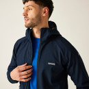 Man zipping up the Regatta AREC III softshell jacket in Navy, paired with a blue technical base layer for a layered outdoor look.