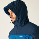 A man in a blue hooded jacket with a slightly rugged look, gazing downward. The jacket has adjustable drawstrings and a "Regatta Outdoors" logo.