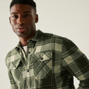 Man wearing a green plaid flannel shirt, smiling slightly against a plain background. The shirt has front pockets, conveying a casual, relaxed vibe. Man wearing a green plaid flannel shirt, smiling slightly against a plain background. The shirt has front pockets, conveying a casual, relaxed vibe.