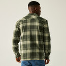 A person from behind wearing a green and cream plaid flannel shirt and blue jeans. The image conveys a casual, relaxed tone. A person from behind wearing a green and cream plaid flannel shirt and blue jeans. The image conveys a casual, relaxed tone.