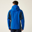 Man in a blue and dark blue hooded jacket stands facing away, wearing matching trousers. The background is a plain, light gray, creating a simple, outdoor-ready vibe.