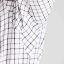 Close-up detail of men’s white check shirt fabric showing the fine woven country check pattern