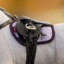 Close-up of a black leather saddle with white stitching, secured on a plush grey horse toy with a quilted lilac saddle pad trimmed in purple, featuring a visible LeMieux tag.
