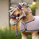 Close-up of a light brown toy horse’s head wearing a lilac headcollar with a soft purple fleece noseband embroidered with “LeMieux” in white, attached to a purple and white twisted lead rope. The toy horse is also wearing a matching lavender fleece rug with dark purple trim.