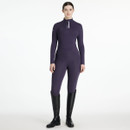 A woman wearing a fitted, long-sleeved, deep plum equestrian base layer top with a quarter-zip front and "LeMieux" branding on the chest and sleeve, paired with matching riding tights and tall black riding boots, standing against a plain white background.