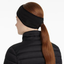 Back view of a woman with long auburn hair in a ponytail, wearing a black fleece ear warmer and black padded jacket.