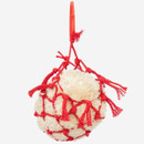 Cream plush haynet ball enclosed in red rope net with knotted tassels and ribbon hanging loop.